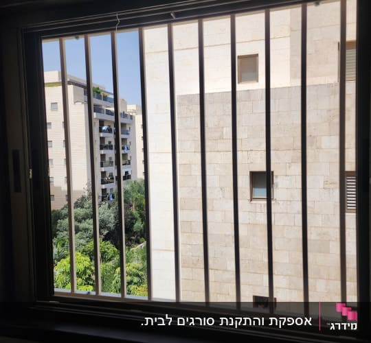 סורגי חלון עם נוף של בניינים ועצים